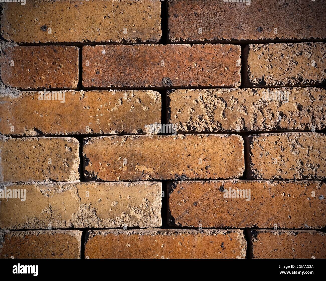 Orange colored grungy brick wall as background Stock Photo