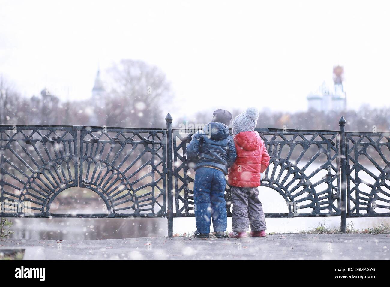 Kids walk in the park with first snow Stock Photo - Alamy