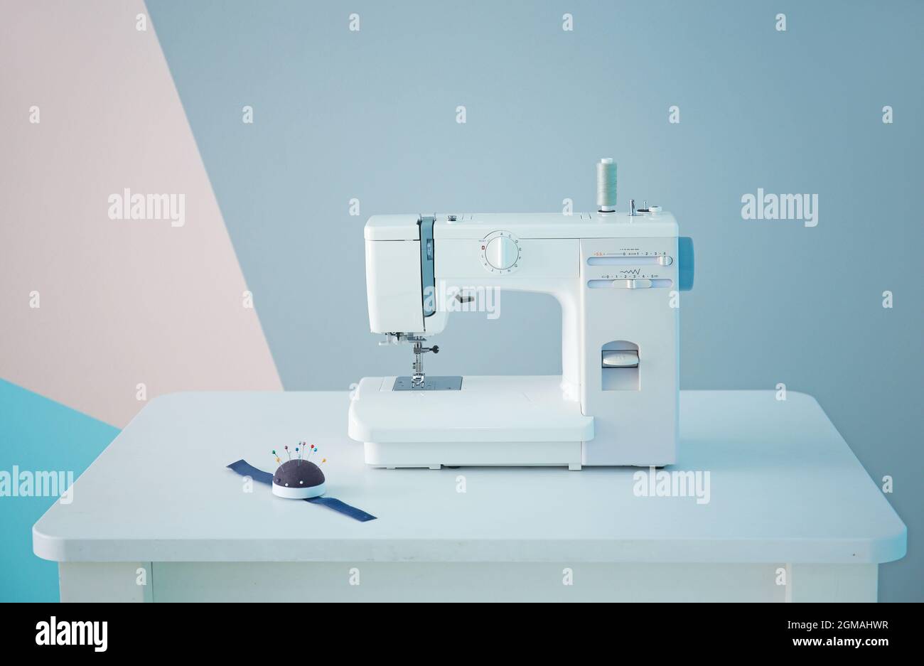 Sewing machine on table in tailor's Stock Photo Alamy