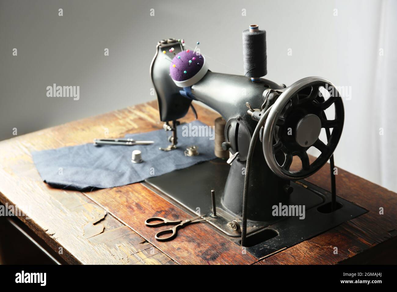 Vintage sewing machine with fabric and threads indoors Stock Photo Alamy