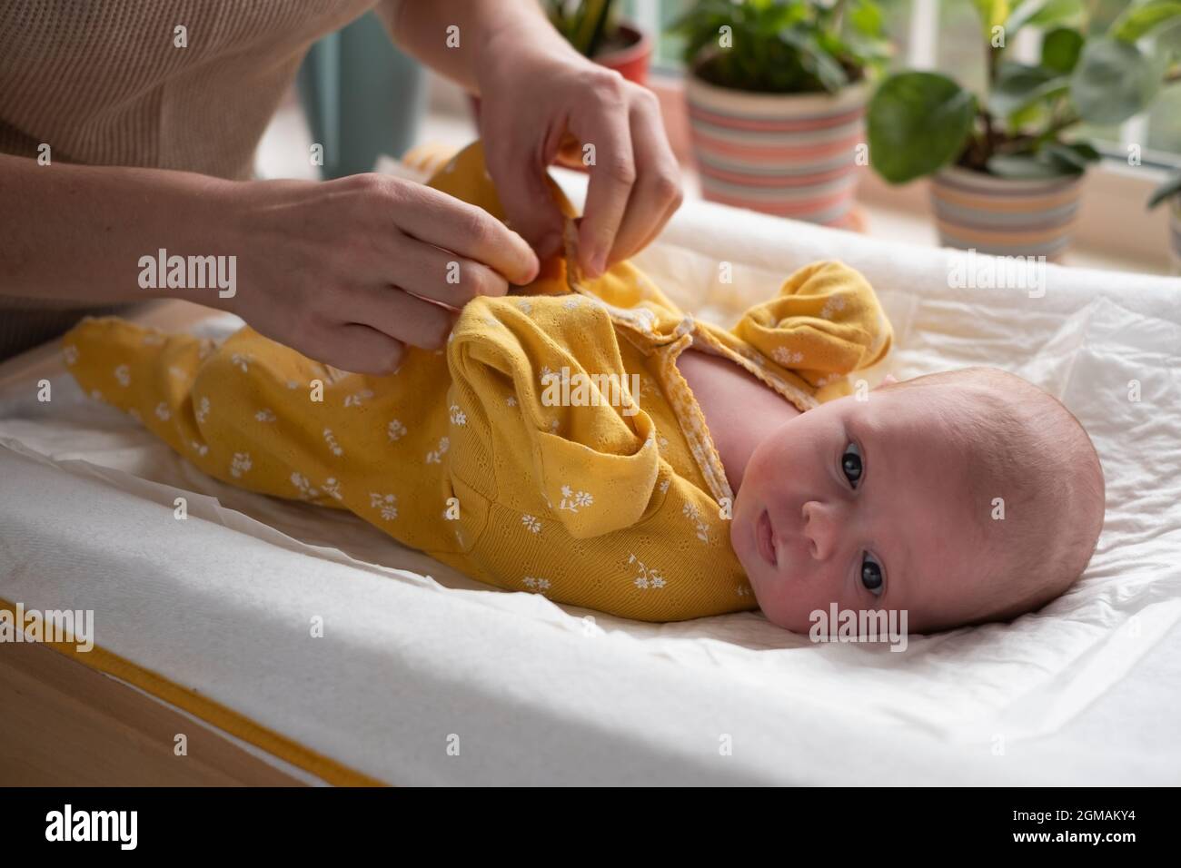 Caucasian mother changing baby girl clean cloth Stock Photo