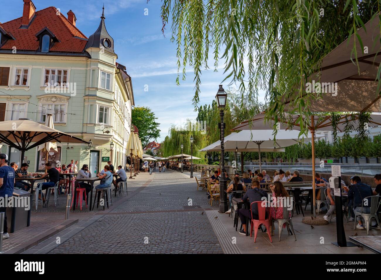 09.08.2021: Ljubljana, Slovenia: People having fun in restaurants and bars next to the charming Ljubljanica river . Stock Photo