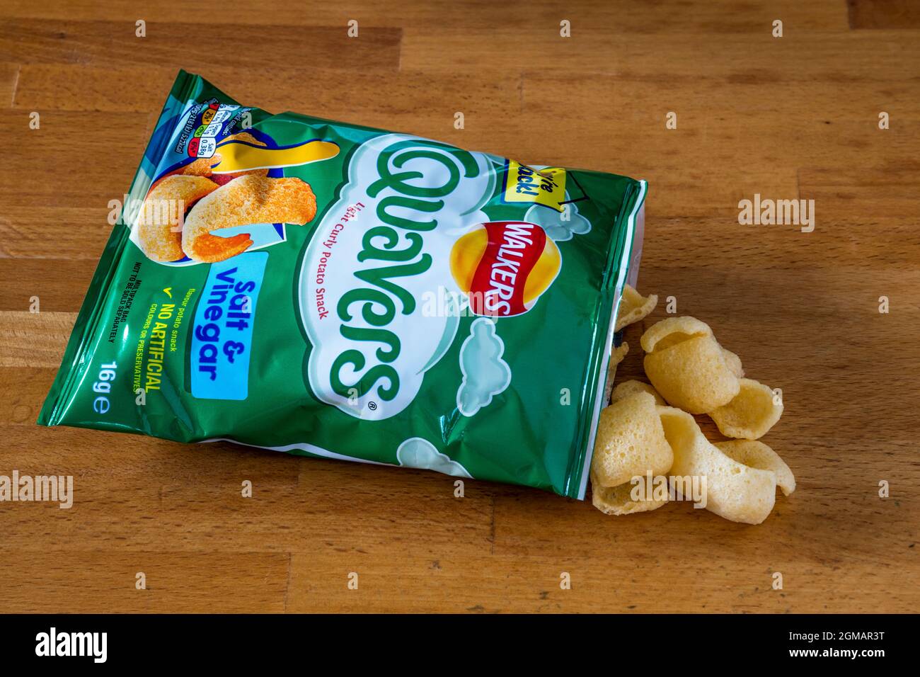 An opened packet of salt and vinegar flavoured Quavers potato snacks. Stock Photo