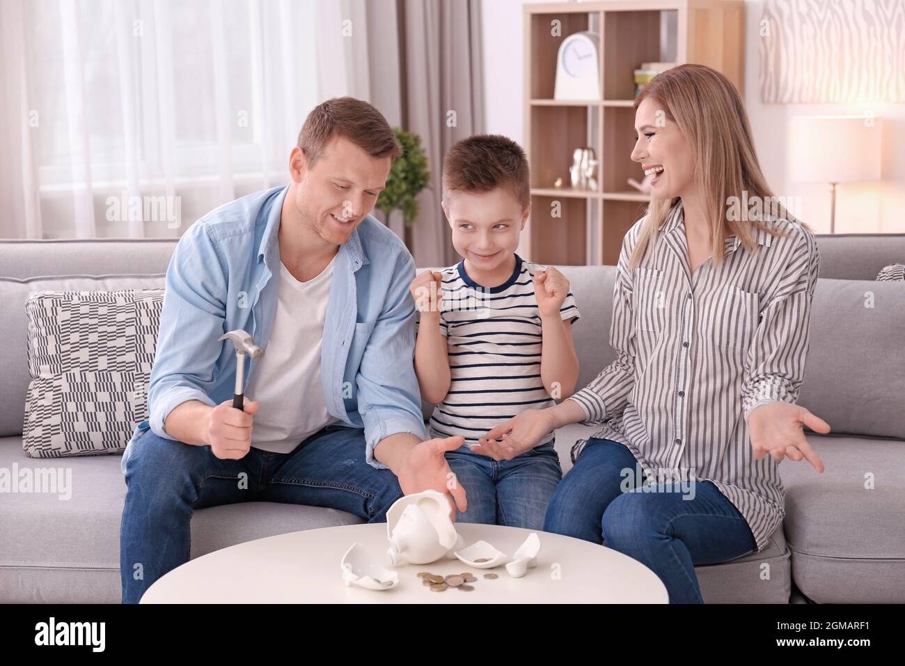 Happy family breaking piggy bank with hammer at home Stock Photo - Alamy