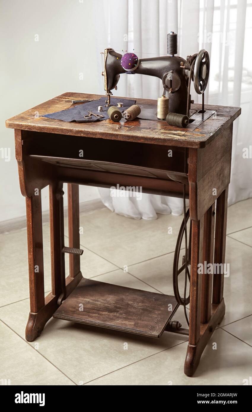 Vintage sewing machine with fabric and threads indoors Stock Photo Alamy