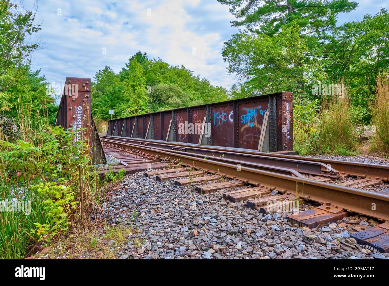 Rusty railway bridge spans a small river near Washago Ontario Canada. Stock Photo