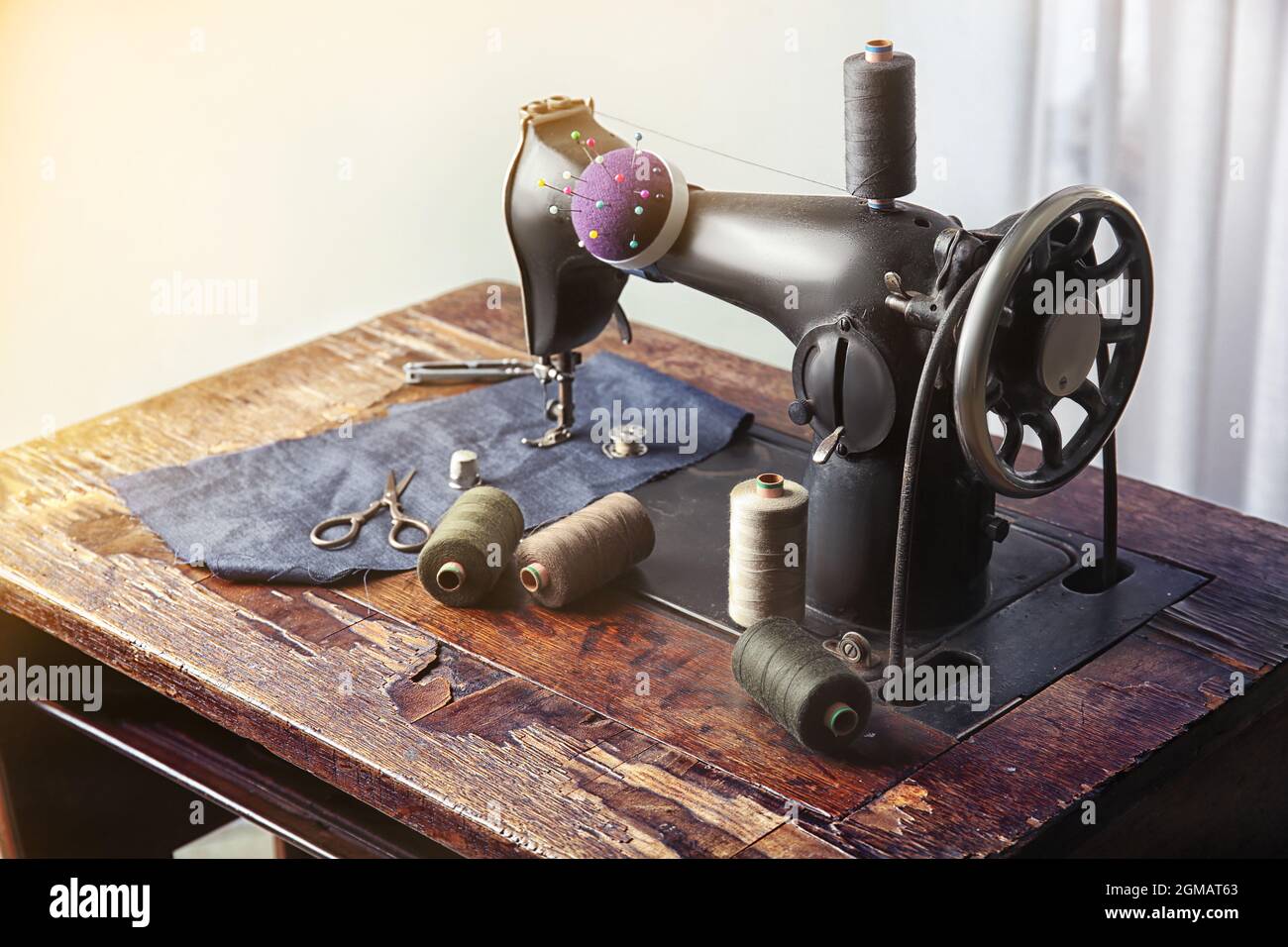 Vintage sewing machine with fabric and threads indoors Stock Photo Alamy