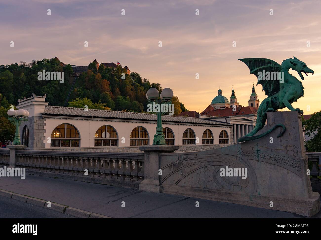 Dragon bridge in Ljubljana in sunset with Castle and cathedral background . Stock Photo