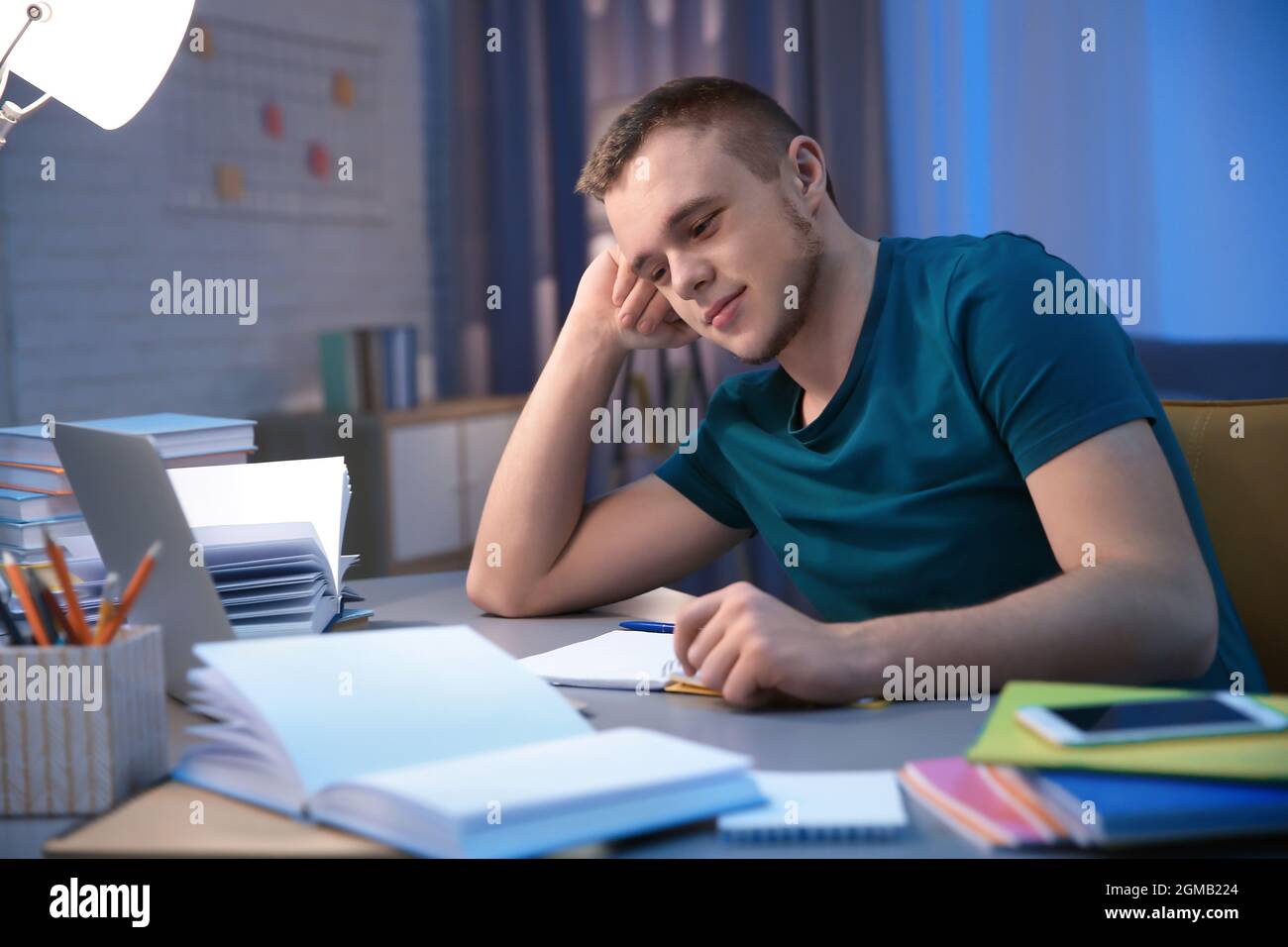 Student doing homework indoors late at night Stock Photo - Alamy