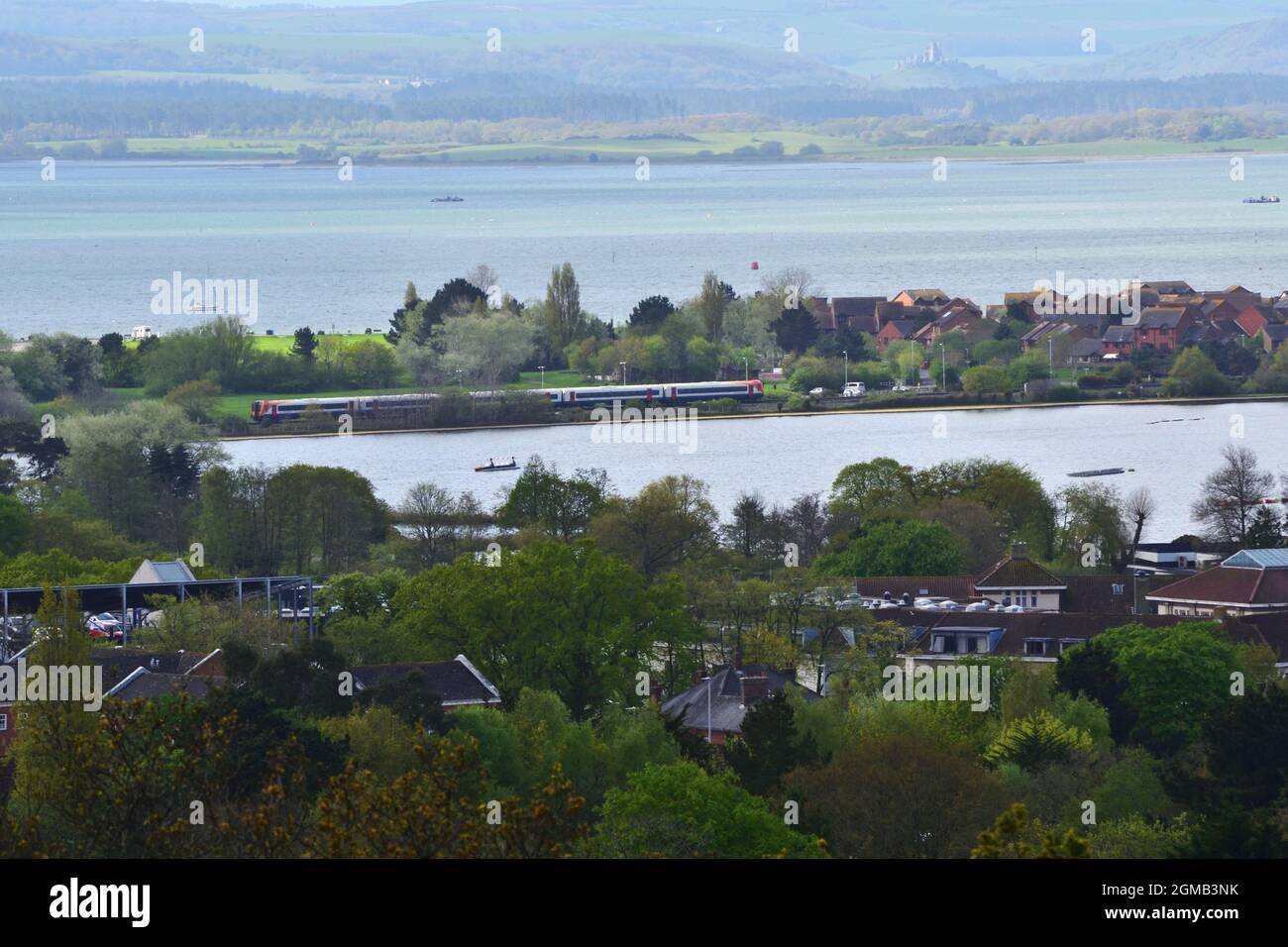 View over Poole Park lake and Poole Harbour, with the Purbeck hills and Corfe Castle in the background. Stock Photo