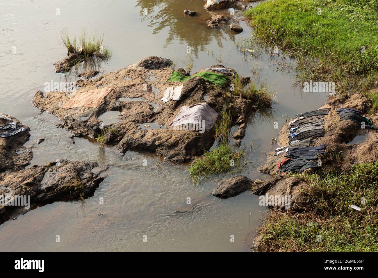 In India, laundry lies on a rock in a river to dry. Stock Photo
