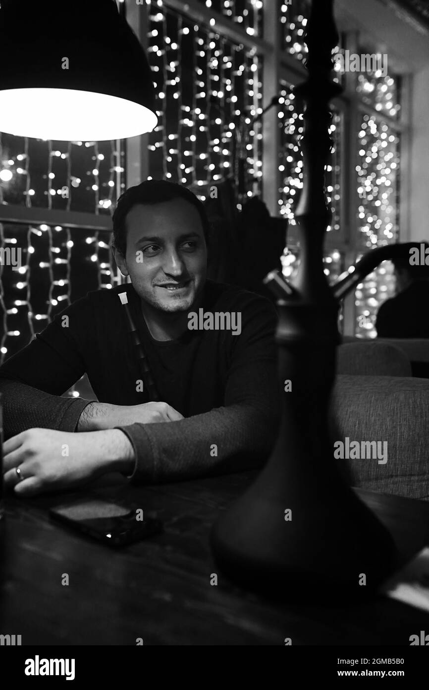 handsome man holding glass of alcohol with ice in a night club Stock Photo