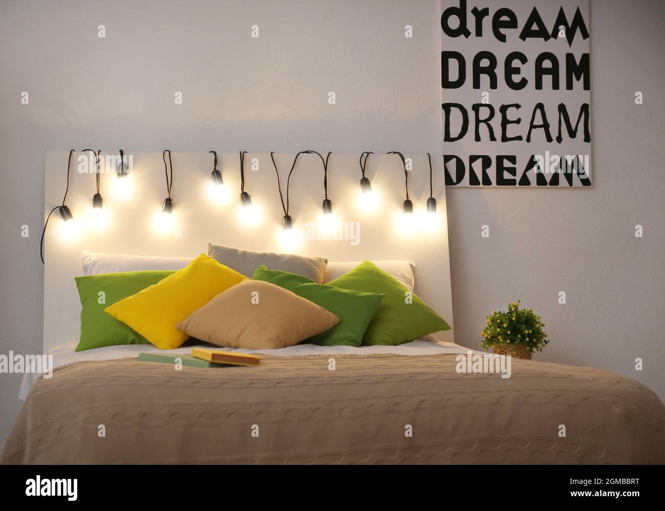 Comfortable double bed decorated with fairy lights at night Stock Photo -  Alamy