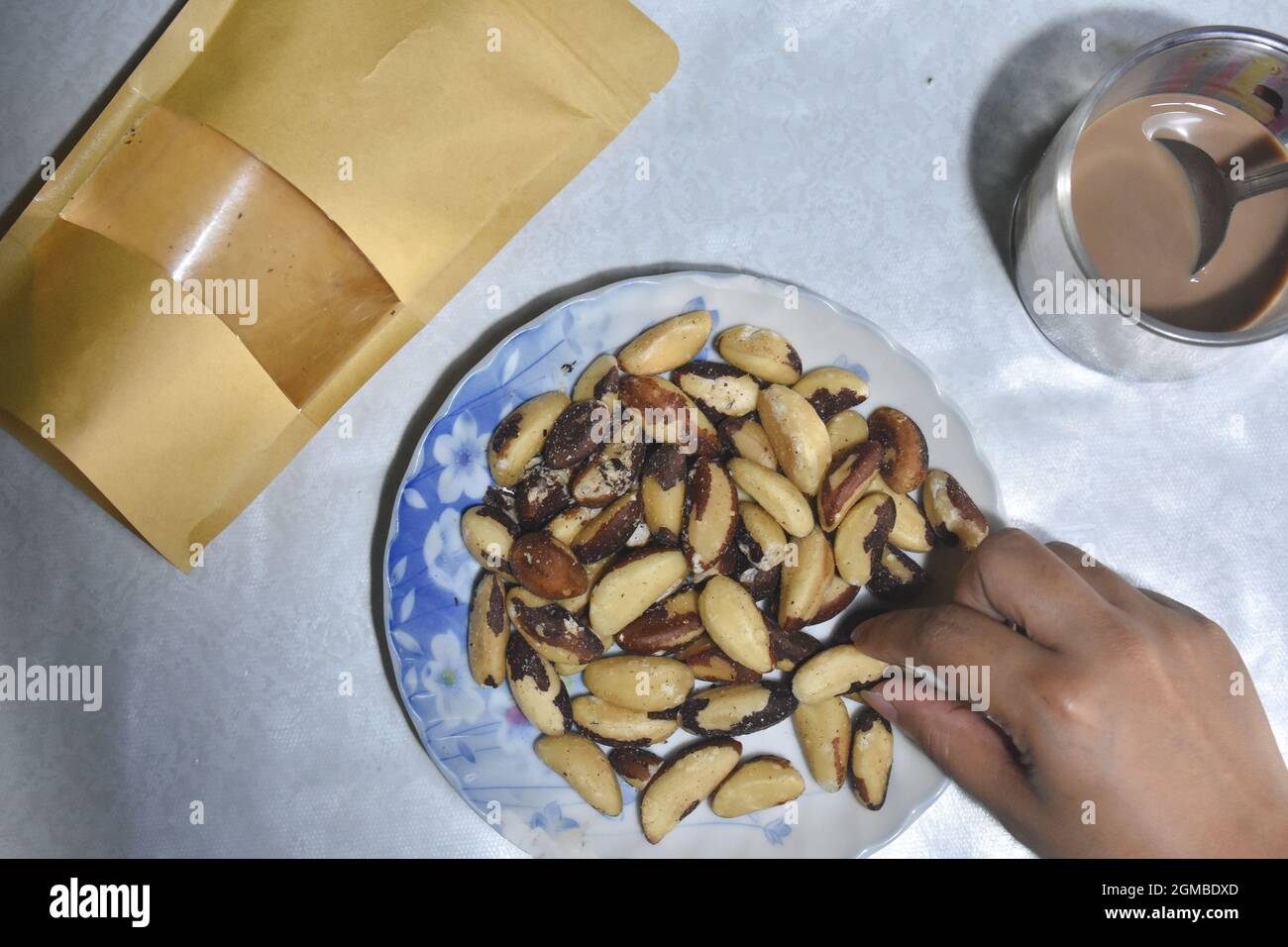 Brazil nuts top view against a table with human hand Stock Photo