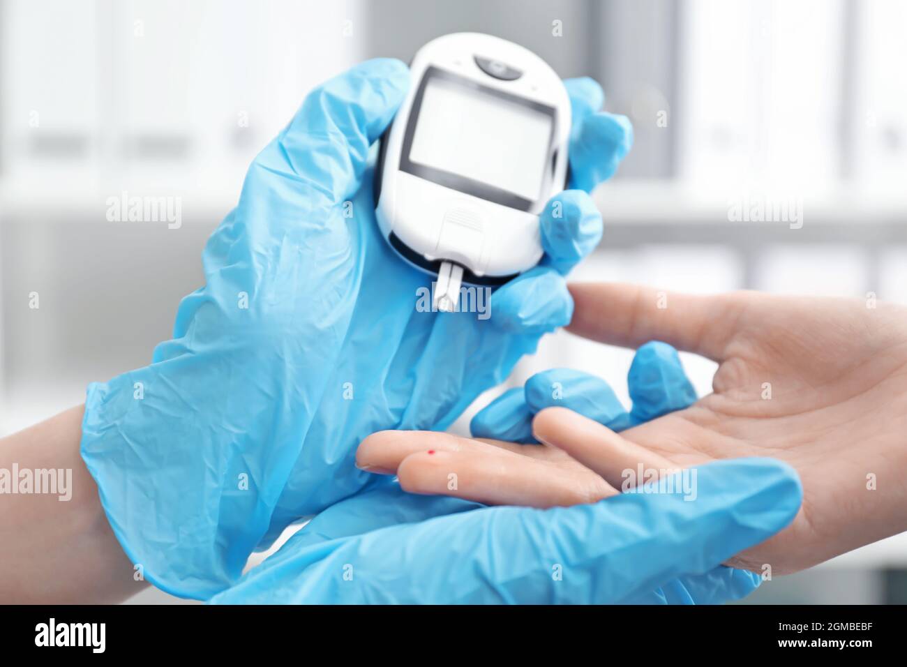 Doctor testing patient's glucose level with digital on