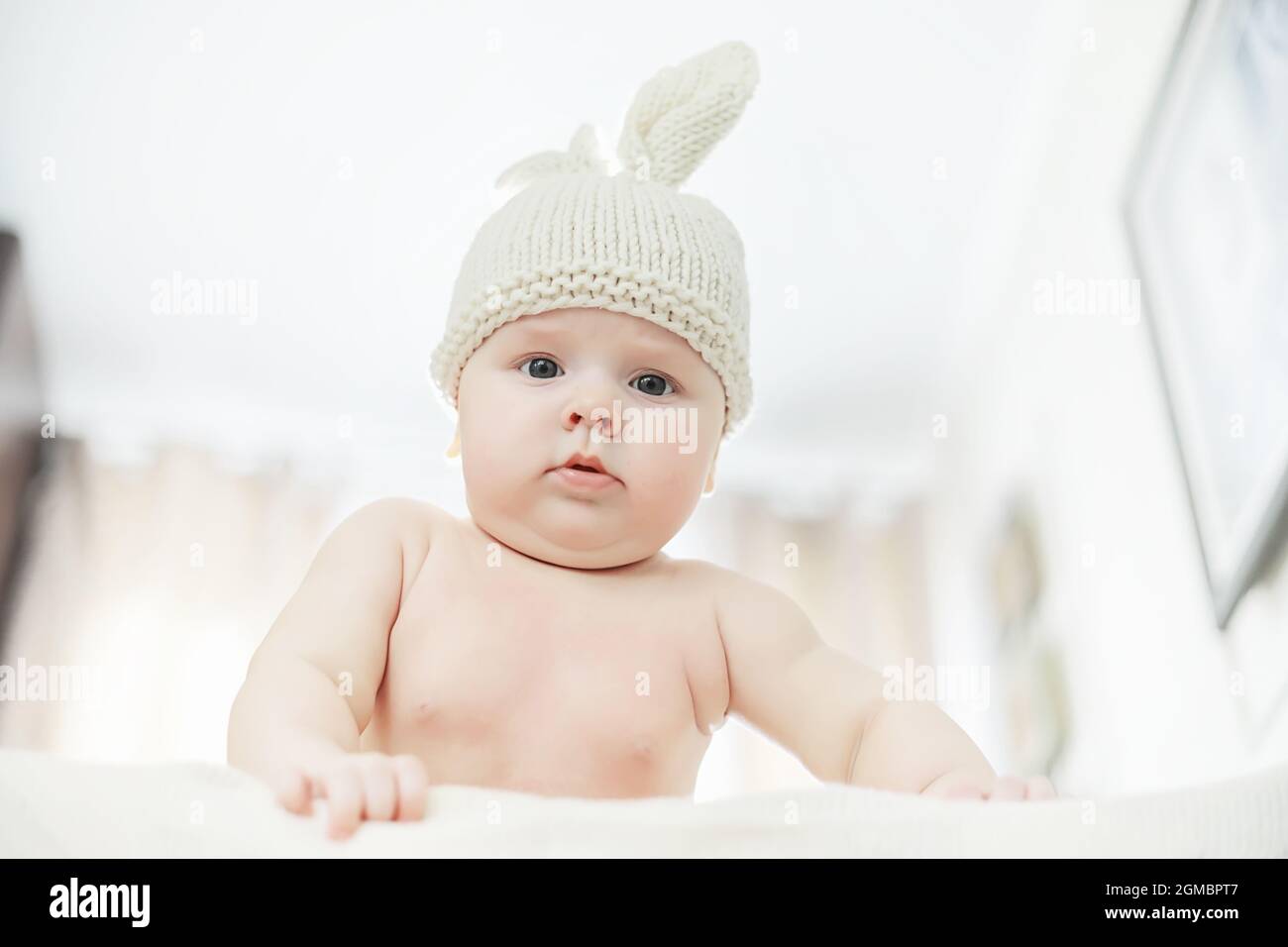 A newborn baby is lying on a soft bed. Children's emotions Stock Photo