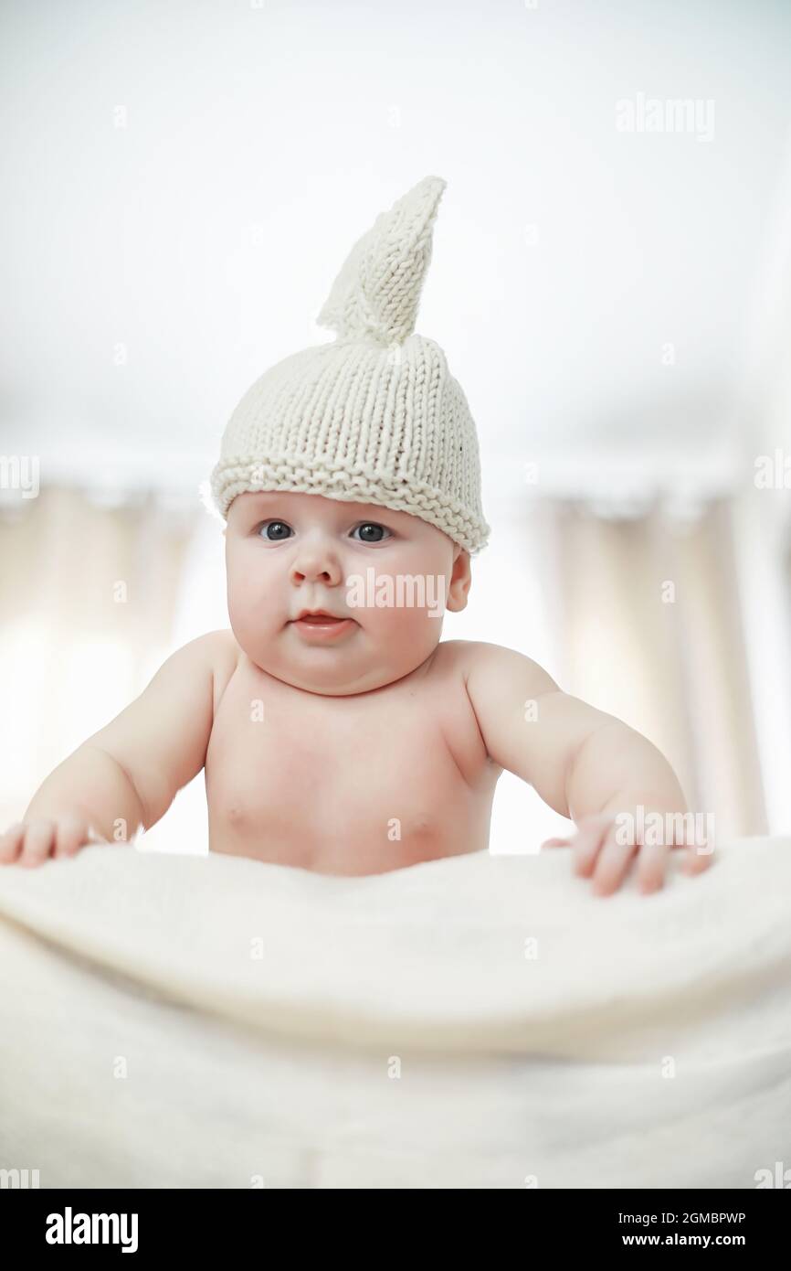 A newborn baby is lying on a soft bed. Children's emotions Stock Photo