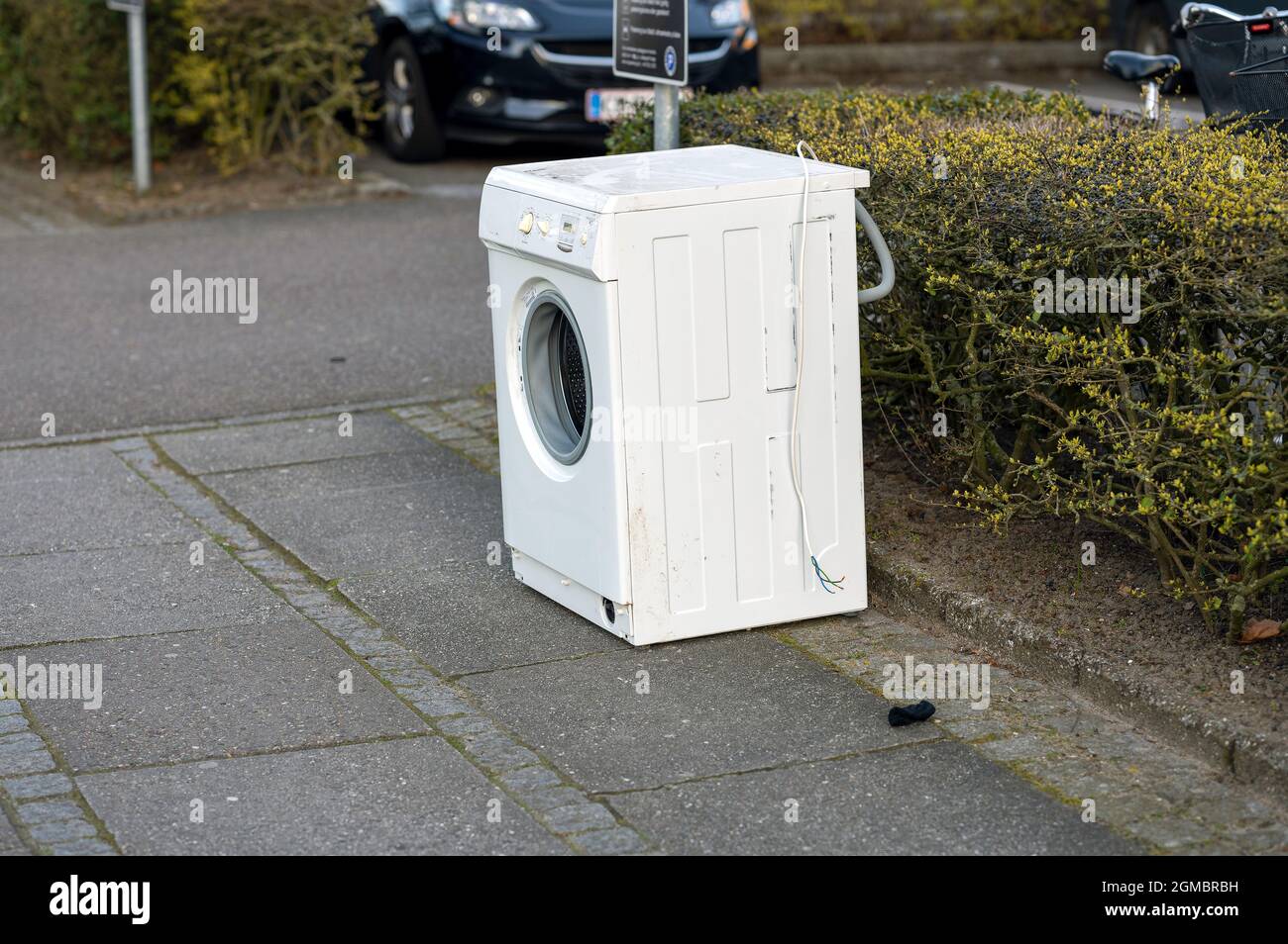 Side view of a washing machine outdoors near a hedge Stock Photo - Alamy