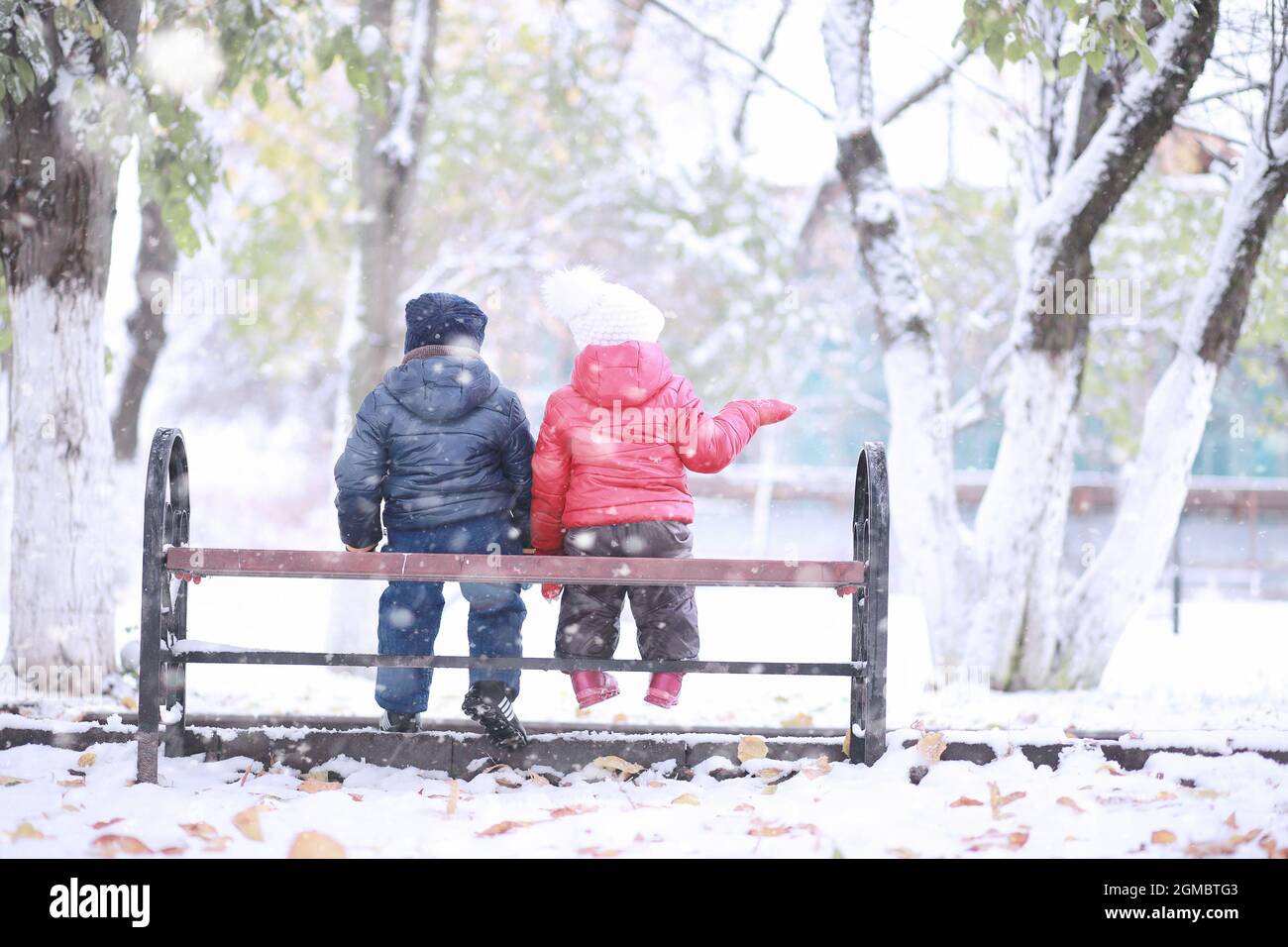 Kids walk in the park with first snow Stock Photo - Alamy