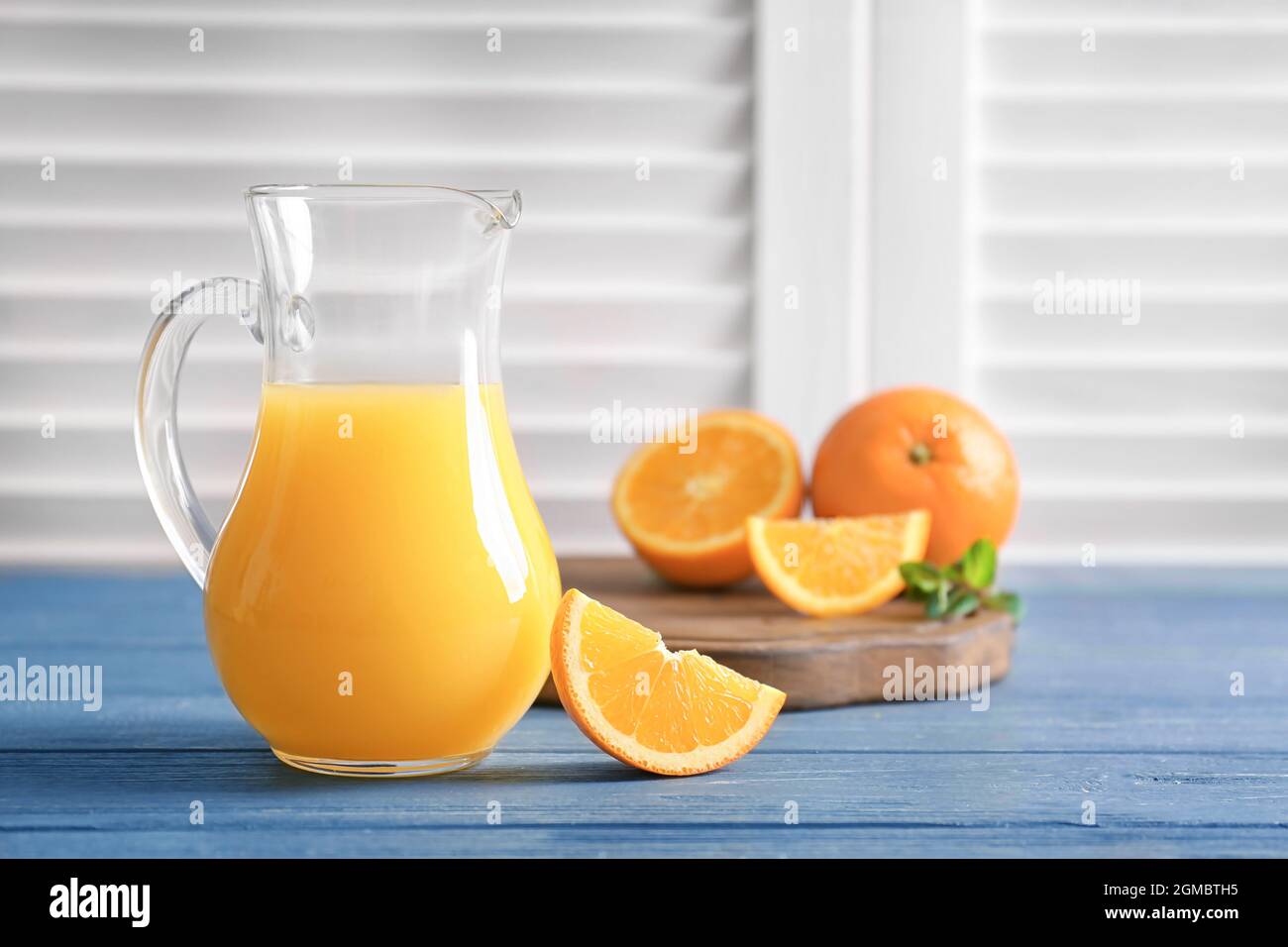 https://c8.alamy.com/comp/2GMBTH5/glass-jug-of-fresh-orange-juice-with-slice-on-wooden-table-2GMBTH5.jpg