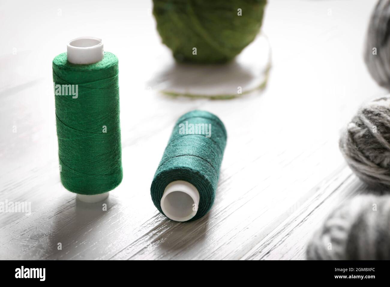 Sewing and woolen threads on wooden background Stock Photo - Alamy