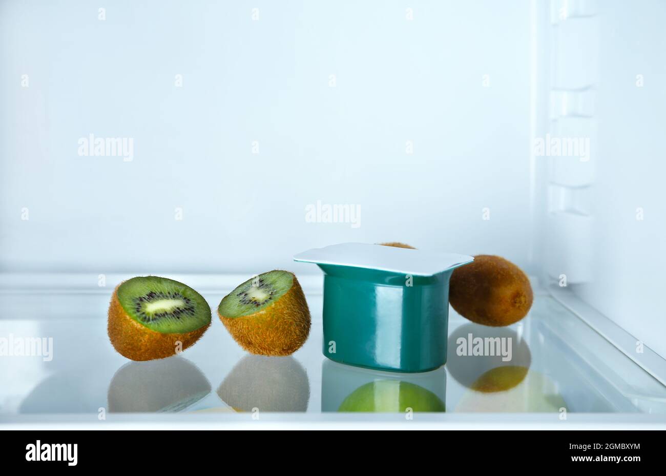 Plastic cup with yogurt and kiwi in refrigerator Stock Photo Alamy