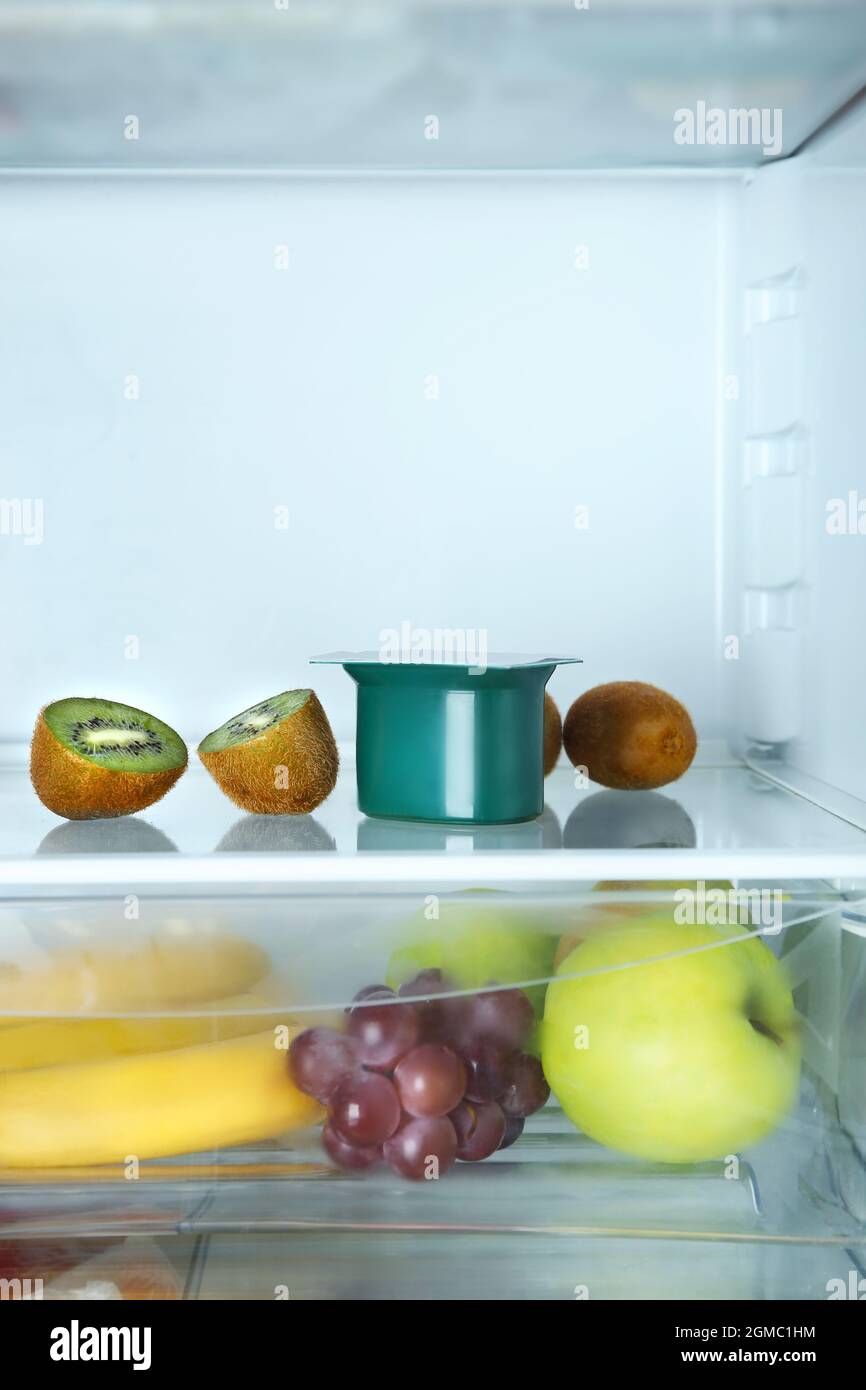 Plastic cup with yogurt and kiwi in refrigerator Stock Photo Alamy