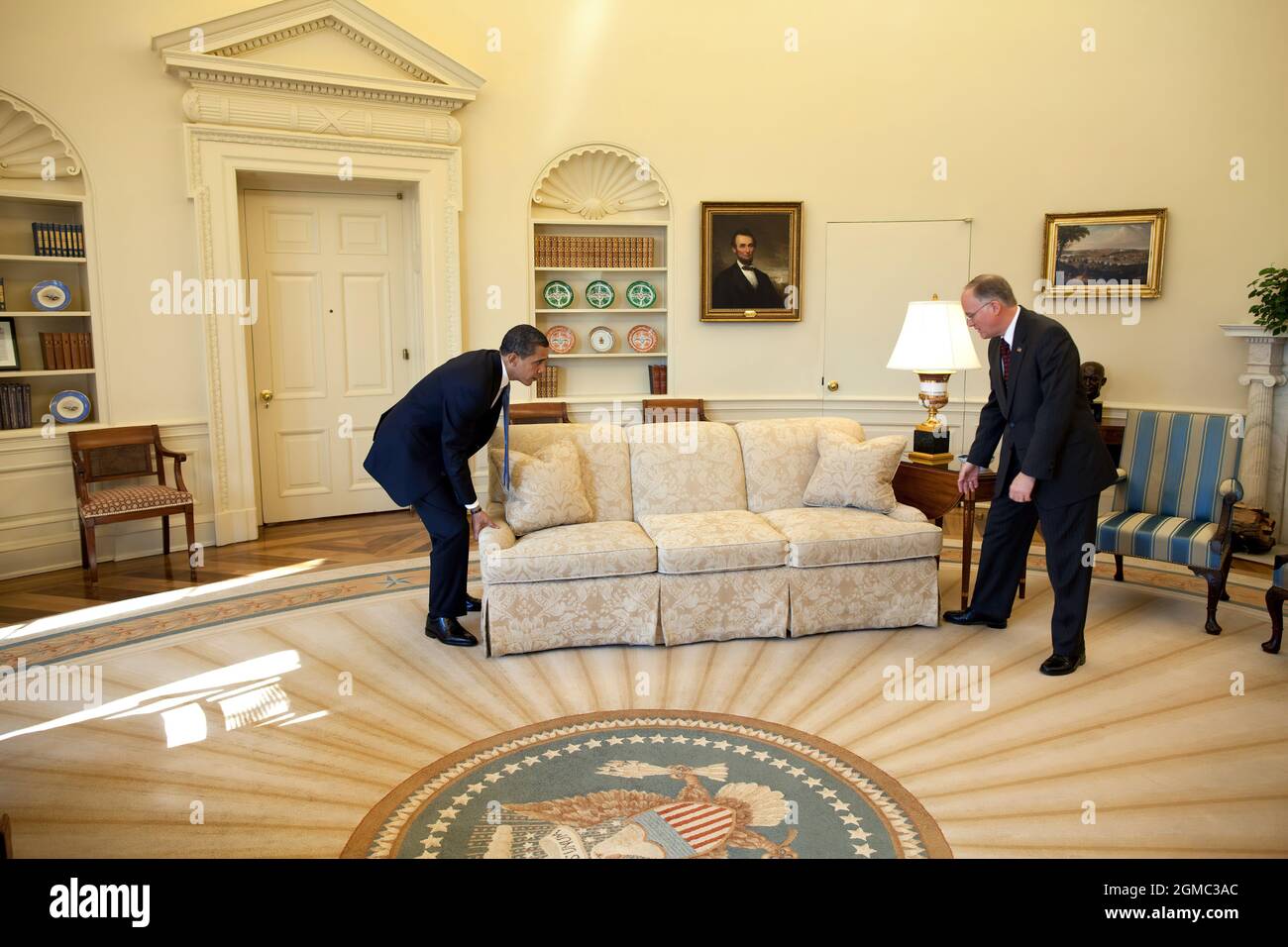 Feb. 2, 2009“White House valets had moved the sofas in the Oval Office to accommodate the large number of press photographers that were covering the President’s meeting with Vermont Gov. Jim Douglas. When the photo-op ended, the President said to Gov. Douglas, ‘let’s move the sofas back in place.’ Gov. Douglas didn’t quite know what to do as the President did the heavy lifting. The valets now good-naturedly cringe when they look at this picture because it was their responsibility to move the sofas back in place.”   (Official White House photo by Pete Souza)  This official White House photograp Stock Photo