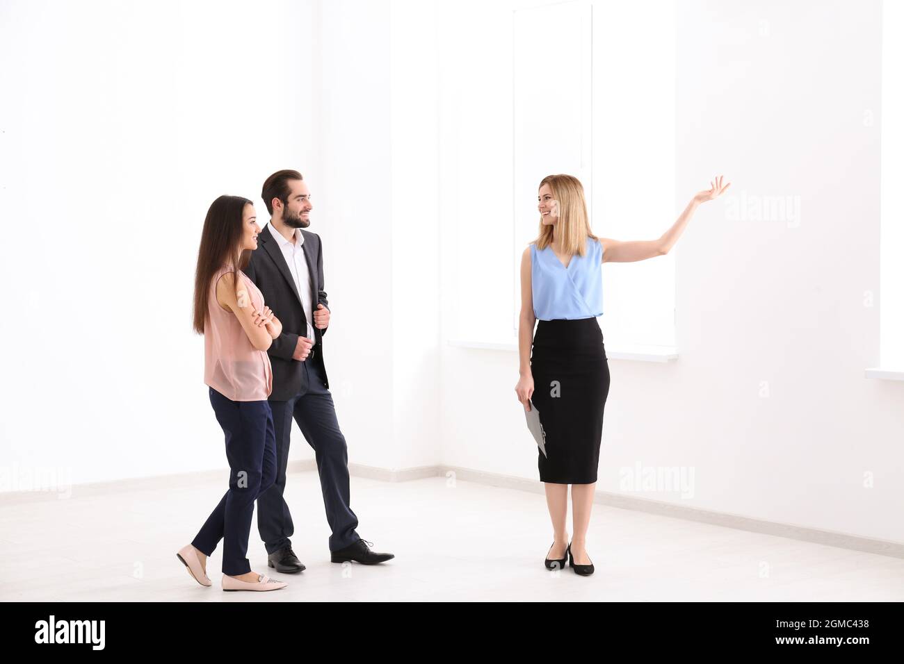 Real estate agent with trainee showing apartment to client Stock Photo