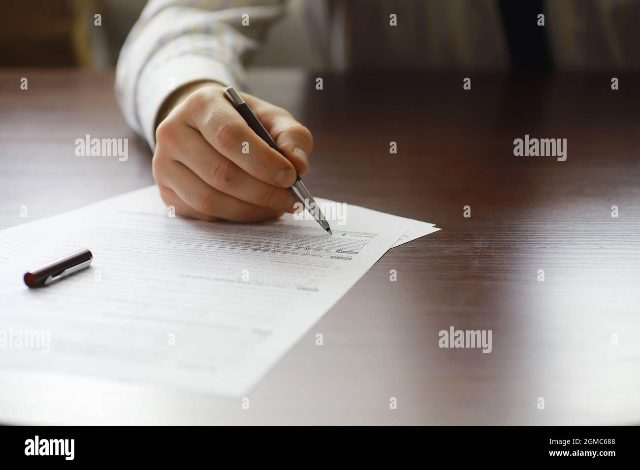 Business meeting. A man signs a contract. Male hand with pen makes ...