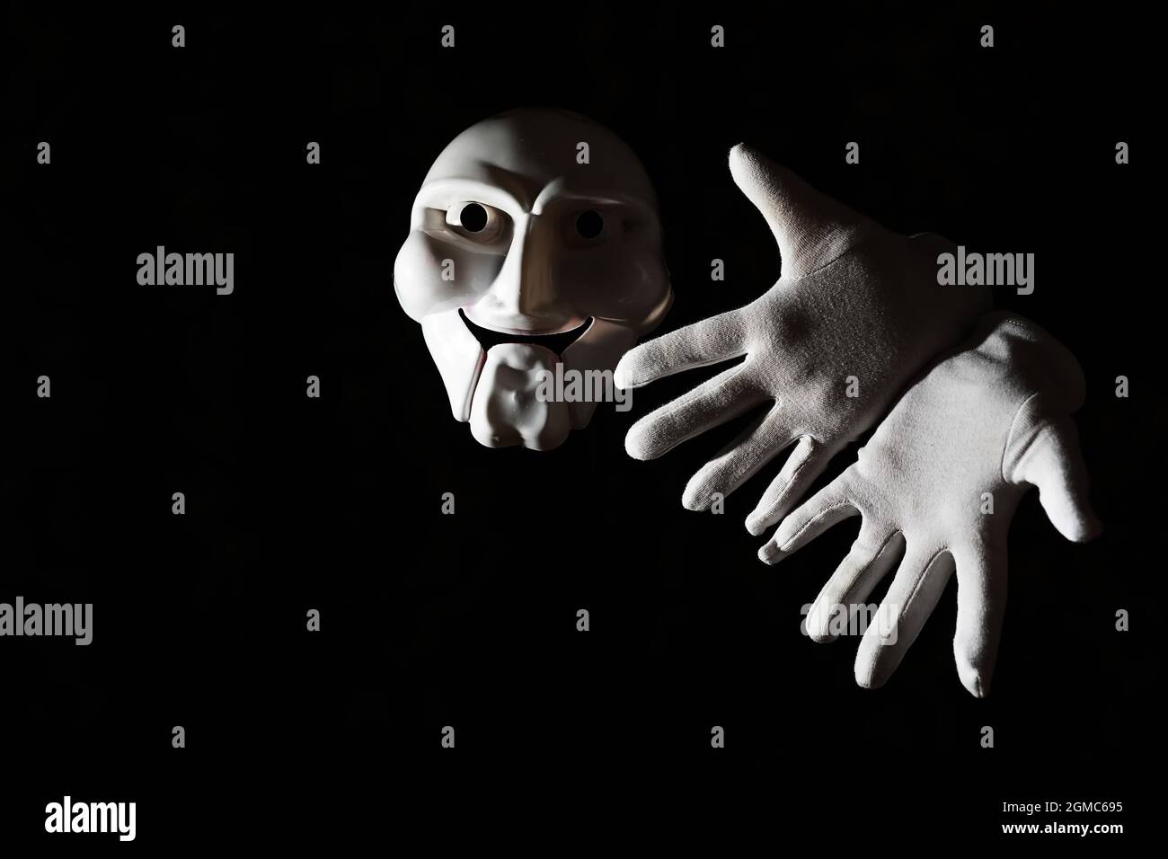 White Scary Mask On A Black Background With Whites Hands Stock Photo