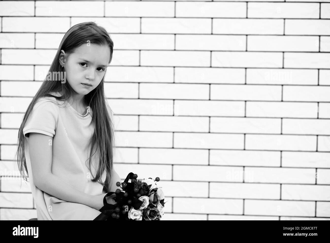 little girl is sitting on a chair and posing on the camera Stock Photo ...