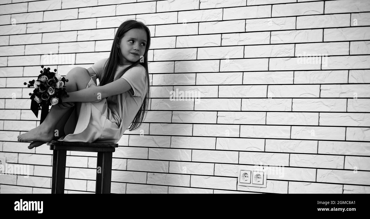 little girl is sitting on a chair and posing on the camera Stock Photo ...