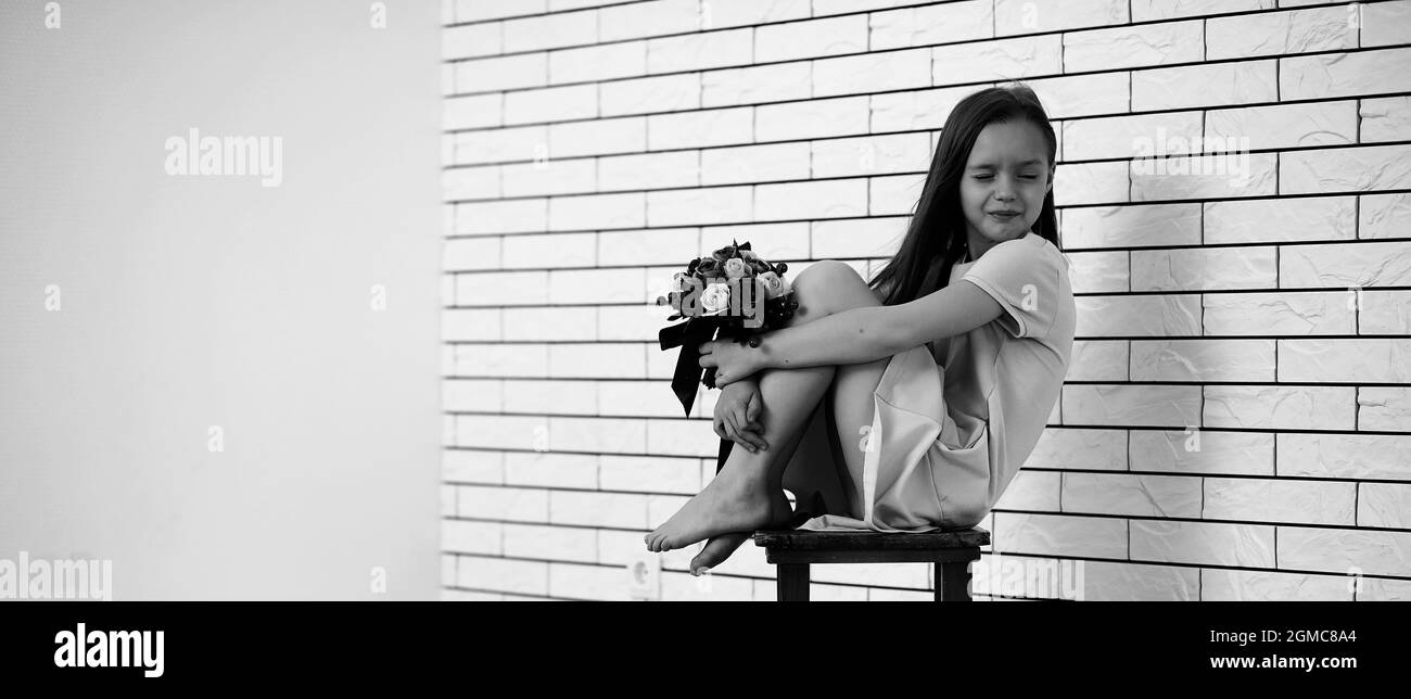 little girl is sitting on a chair and posing on the camera Stock Photo ...