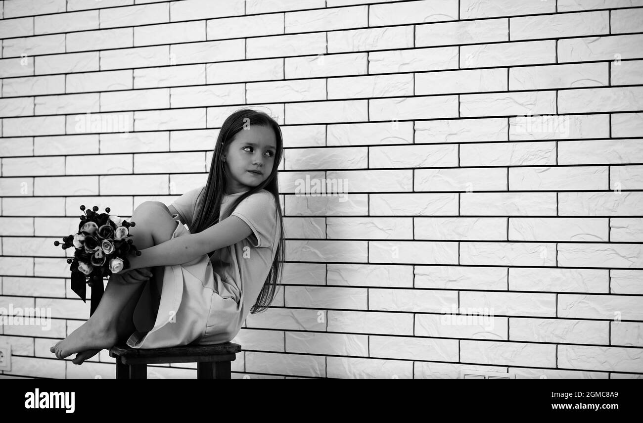 little girl is sitting on a chair and posing on the camera Stock Photo ...
