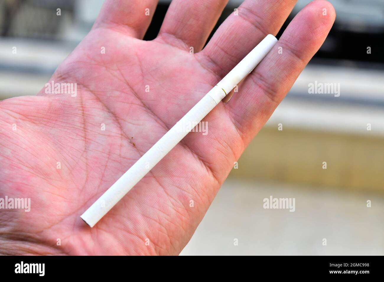 slim cigarette in hand, outdoor smoking concept, slim cigarette Stock