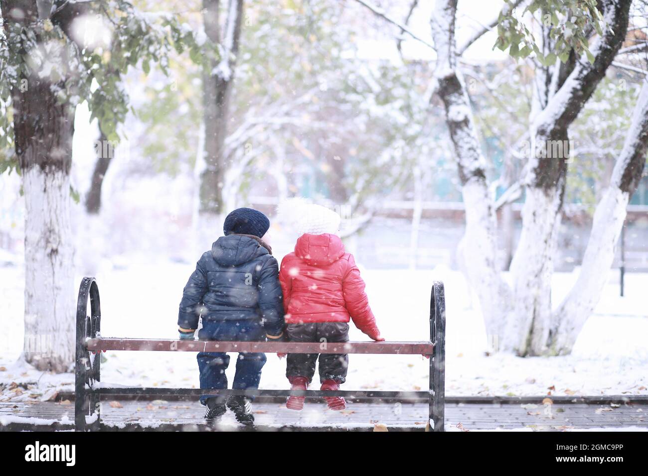 Kids walk in the park with first snow Stock Photo - Alamy