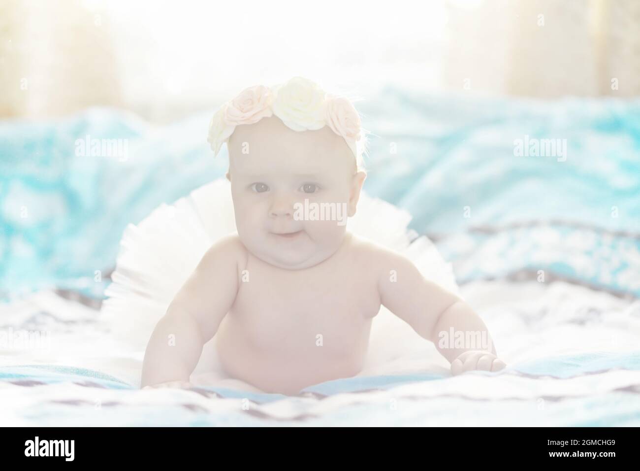 A newborn baby is lying on a soft bed. Children's emotions Stock Photo