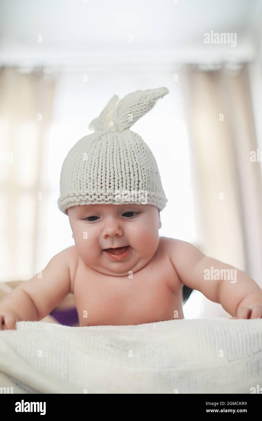 A newborn baby is lying on a soft bed. Children's emotions Stock Photo
