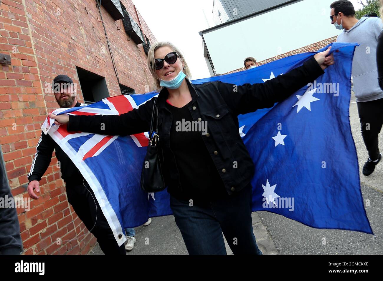 Melbourne, Australia, 18 September, 2021. A protester holds up an Australian flag during the Freedom protest on September 18, 2021 in Melbourne, Australia. Freedom protests are part of an international co-ordinated protest movement targeting governments COVID-19 restrictions, vaccination, and public health efforts.  Credit: Dave Hewison/Speed Media/Alamy Live News Stock Photo