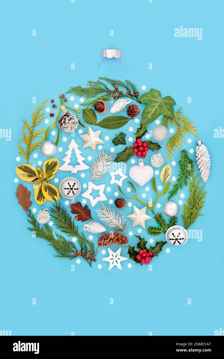 Christmas round shape bauble decoration concept with natural European greenery, snowflakes, Xmas decorations, winter flora on blue background. Stock Photo