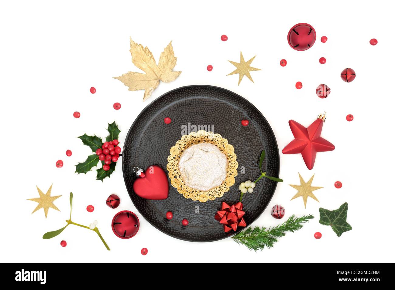 Christmas mince pie on a plate with winter greenery, loose holly ...