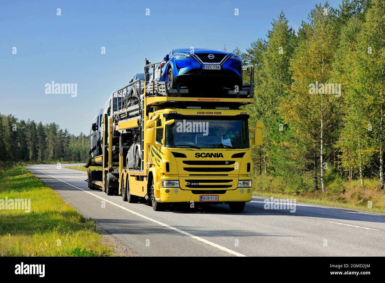 Yellow Scania P450 car carrier truck transports vehicles on road 25 on a sunny day of autumn. Raasepori, Finland. September 9, 2021. Stock Photo