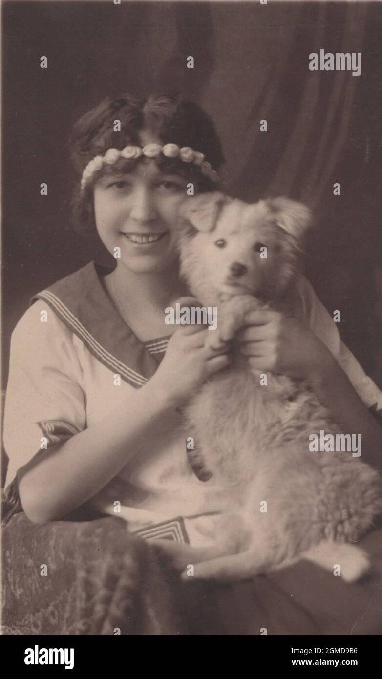 original vintage photo from the 1930's little girl holding her little puppy dor for a close up studio photo. Stock Photo