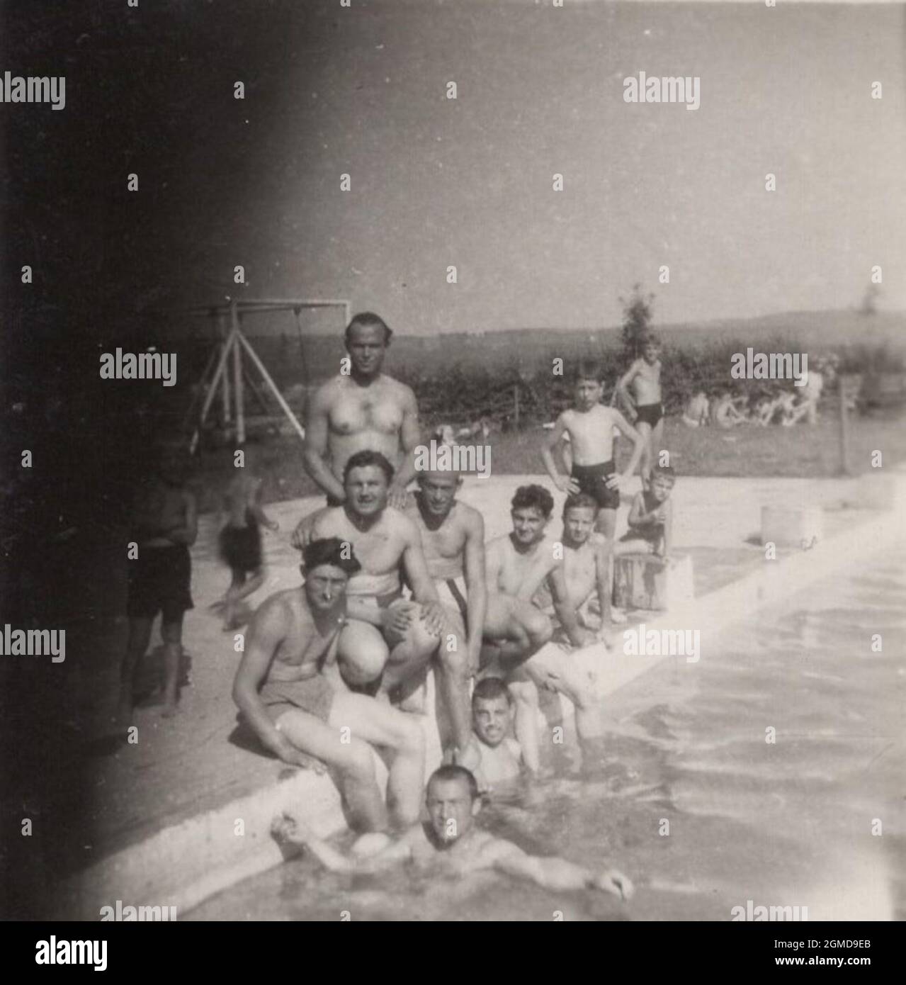 original retro monochrome photo from a professional photographer, whose finger almost cover half of the picture. Friends and family members at the beach, swimming pool, and trying to posing for the photographer. Next time is going to be better. (1950's) Stock Photo