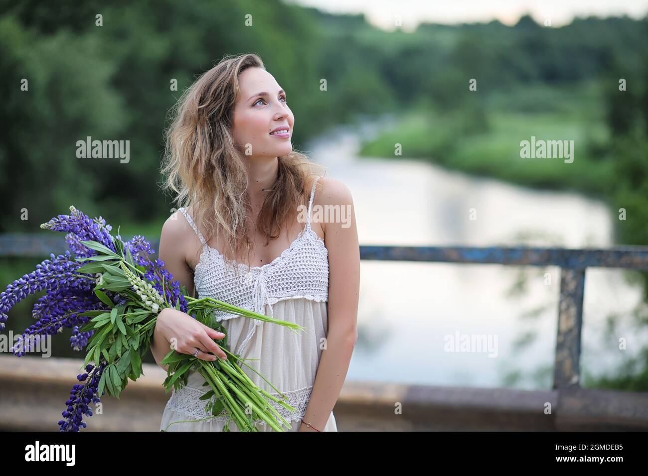 Beautiful girl with a bouquet of blue flowers on nature in summer Stock ...