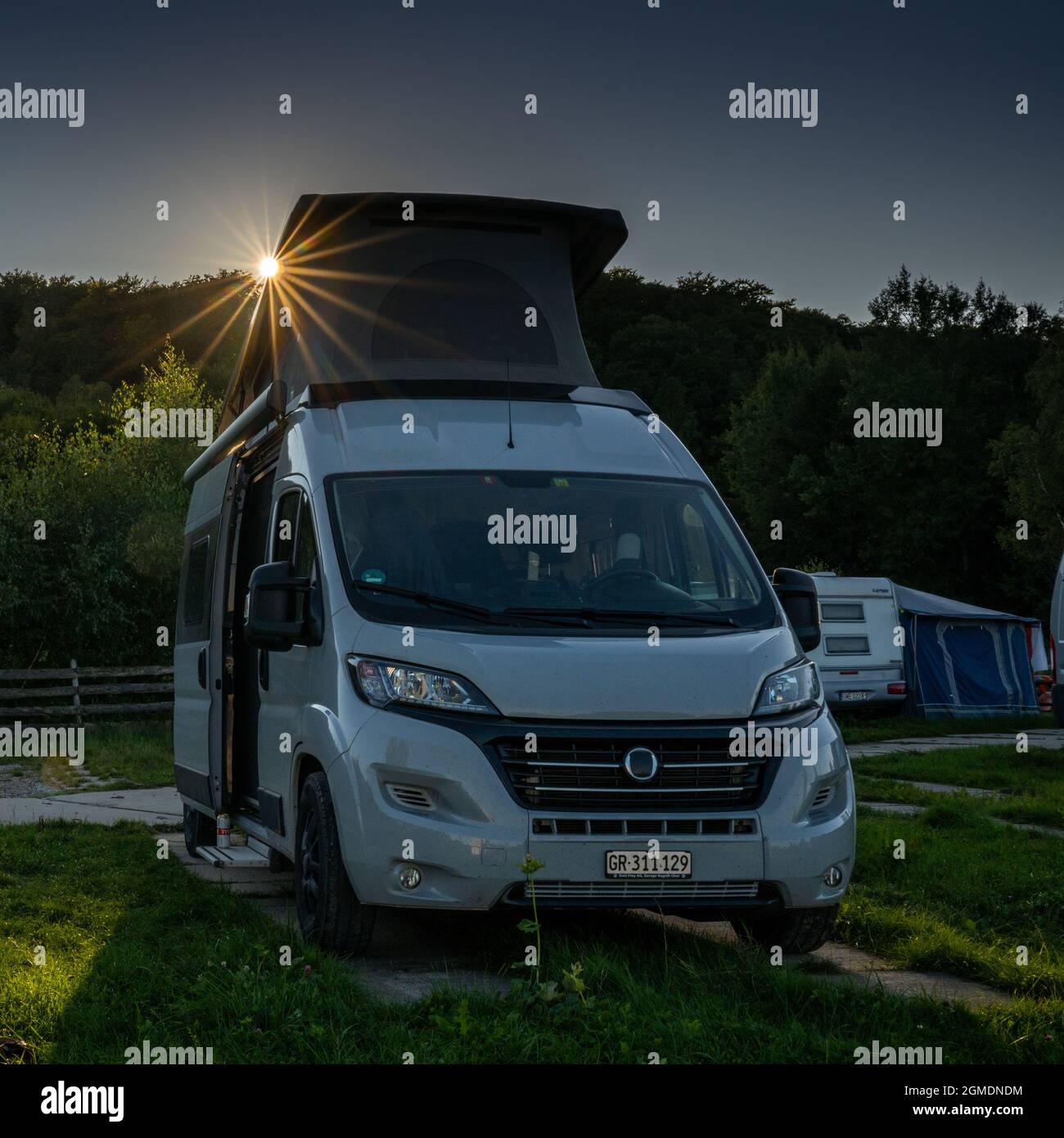 Wejherowo, Poland - 2 September, 2021: gray camper van with a pop-up roof  parked in a campground with evening light and a sun star Stock Photo - Alamy