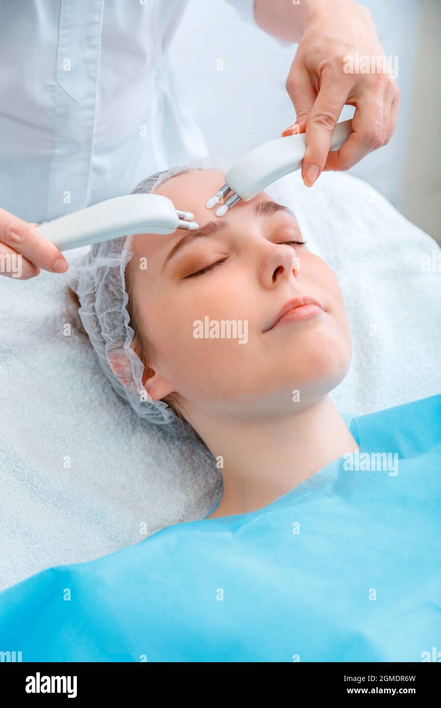 Cosmetology procedure Microcurrents. Beauty Doctor cosmetologist doing aesthetics facial therapy microcurrents. Cosmetology services to woman Stock Photo