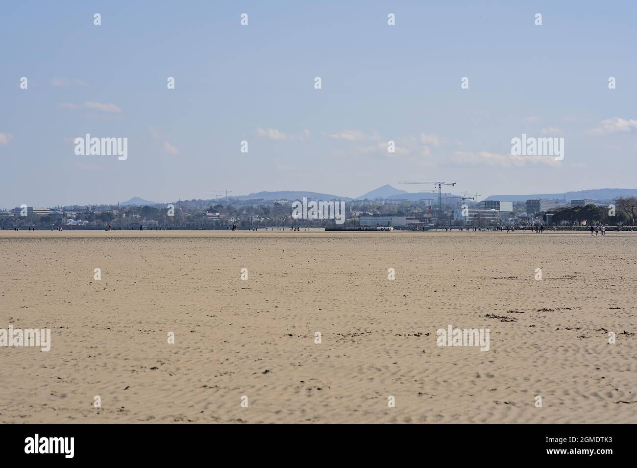 Beautiful bright view on South Dublin and the Mountains seen from Sandymount Beach, Dublin, Ireland during lowest tide. Walking people. Open spaces Stock Photo
