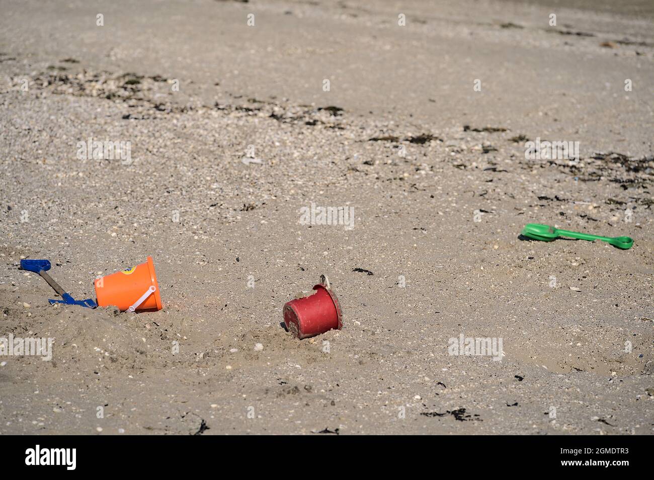 Closeup view of colorful children plastic toys left or forgotten at Sandymount Beach after messy sea activities during lowest tide, Dublin, Ireland Stock Photo